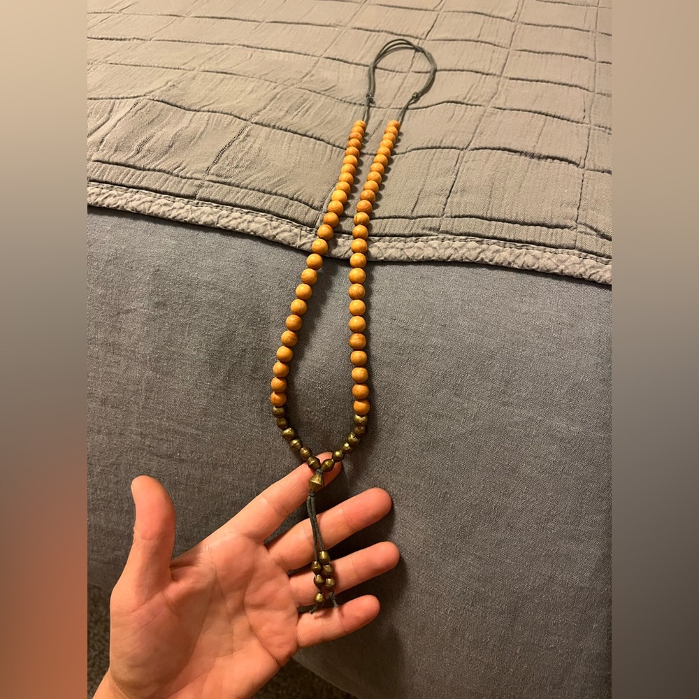 Sandalwood and brass bead necklace on waxed cord